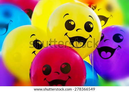 Colorful balloons with happy smiling faces background. Image with selective focus and blur effects