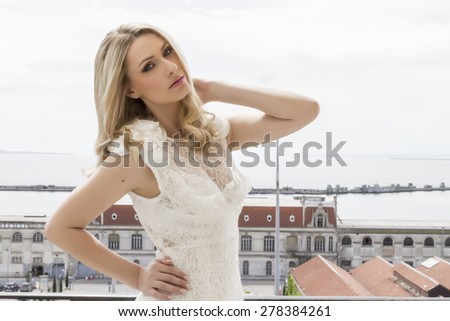 Beautiful bride at the balcony of luxury hotel room with wedding dress