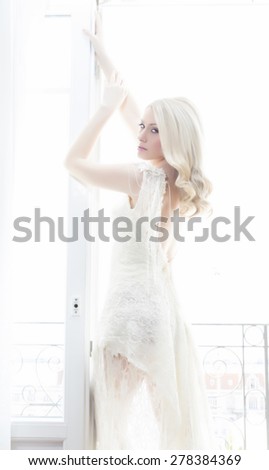 Beautiful bride in luxury hotel room with wedding dress