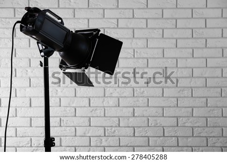 Photo studio with lighting equipment on brick wall background