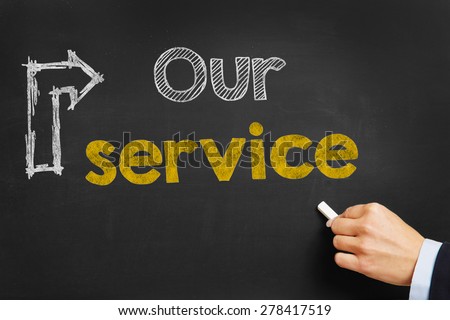 Hand writes "Our Service" on blackboard