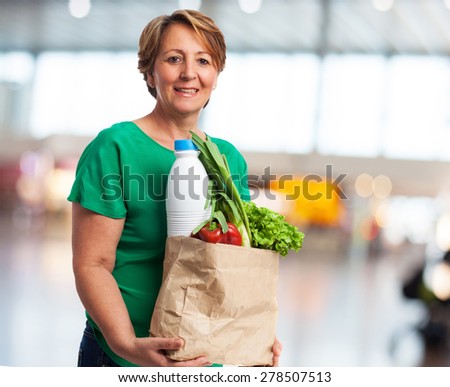 portrait of a mature woman carrying a shopping bag with food