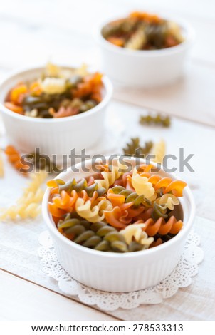 Italian Penne Rigate Macaroni Pasta raw in ramekin bowl, food background