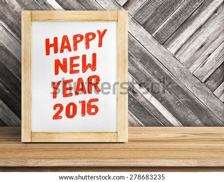Happy New Year 2016 word on wood frame on table and diagonal plank wooden wall,Leave space beside frame to add more text.