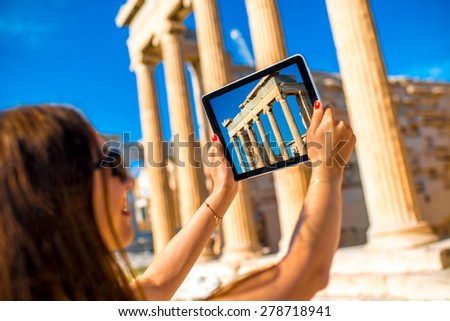 Young woman photographing with digital tablet Erechtheum temple in Acropolis