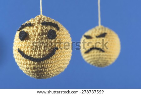 Knitted yellow emoticons on blue background