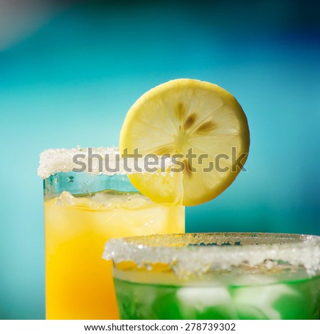 Two tropical cocktails near swimming pool
