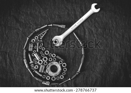 Ying yang symbol composed of the tools and screw on a dark background