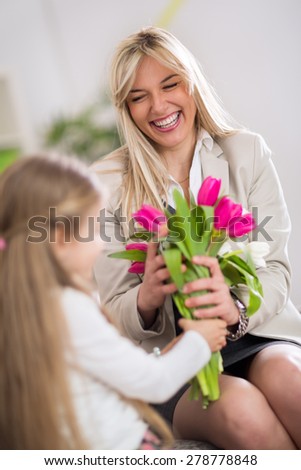 
Happy mom receiving bouquet of tulips from her daughter