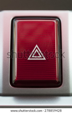 pushed red warning button with triangle pictogram, close up view and flasher light. 
