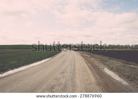 empty country road in spring with perspective and shadows - retro vintage grainy film look
