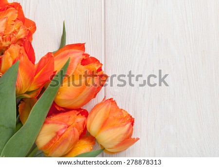 Colorful tulips over wooden table background with copy space