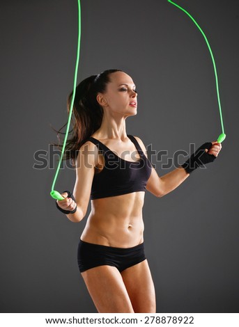 Full length view of an attractive woman with jumping rope. Royalty-Free Stock Photo #278878922
