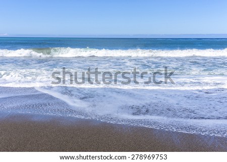 Waves, sand, blue sky and sea, on Moonstone Beach, California Central Coast, near Cambria CA.