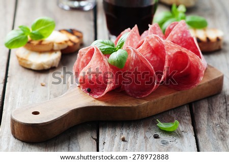 Delicious salami with basil and wine, selective focus Royalty-Free Stock Photo #278972888