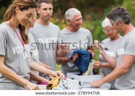 Happy volunteer looking at donation box on a sunny day Royalty-Free Stock Photo #278994758