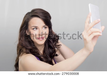 Brunette woman taking a photo of her self on a mobile device