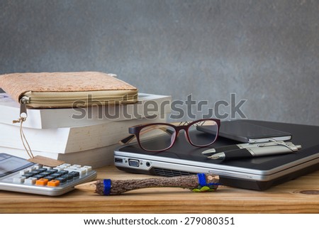 Books with stationary, and laptop on wooden table over grunge background