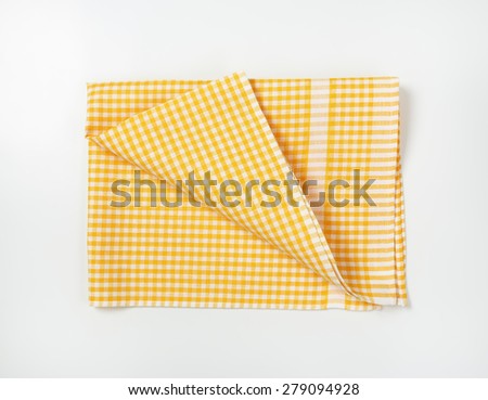 yellow and white checkered tablecloth on white background