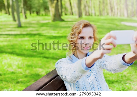 young girl student having fun and taking selfie photo on smartphone camera outdoor in green park in sunny day, teenage trand, people concept  