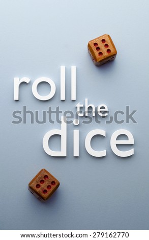 Wooden dices and roll the dice text over blue background, above view