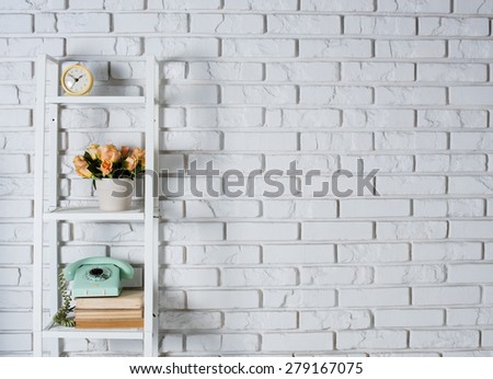 Shelf with interior decoration in front of a white brick wall, vintage decor Royalty-Free Stock Photo #279167075