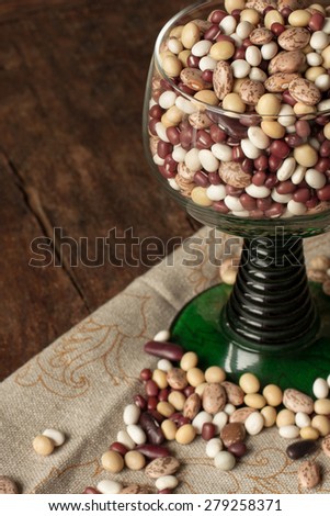 beans and peas in a green glass standing on linen