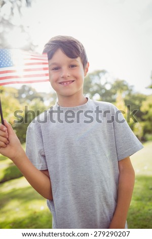 Little boy waving american flag on a sunny day