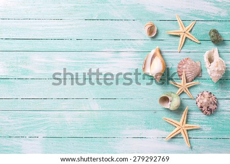 Fresh  spring white and pink  tulips and narcissus in grey bucket, heart, candles in decorative bird cages in ray of light  on white painted wooden background against turquoise wall. Selective focus.  Royalty-Free Stock Photo #279292769