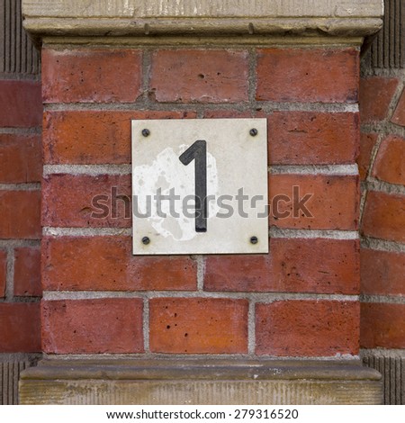 House number one on a brick wall