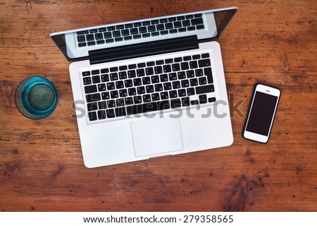 laptop and smart phone on wooden background, top view