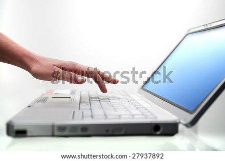Closeup of a female hand typing on laptop computer.