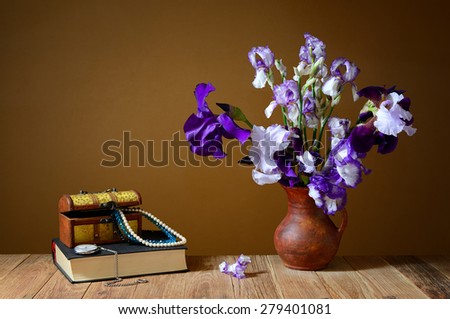 Blue Iris, a book and a box with jewelry on the table