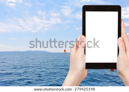 travel concept - tourist photograph red yacht in blue Adriatic sea, Dalmatia, Croatia on tablet pc with cut out screen with blank place for advertising logo