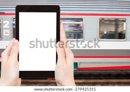 travel concept - tourist photograph fast speed train on railway station on tablet pc with cut out screen with blank place for advertising logo