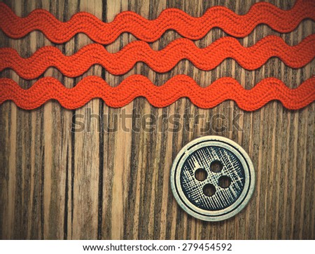 vintage button and old three red tape on a textured surface aged boards. instagram image filter retro style