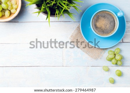 coffee cup with grapes and a wooden background