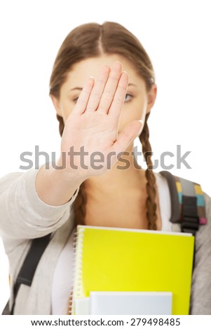 Teenager girl with school backpack make stop gesture.