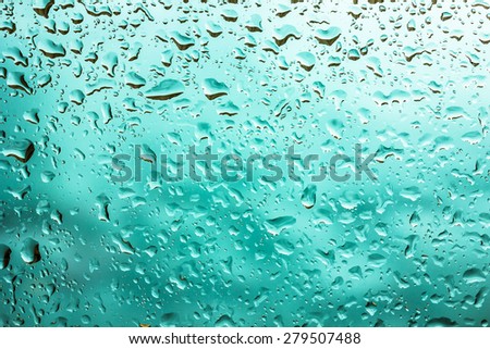 Water drops on glass with blue background.