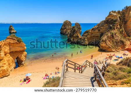 Wooden footbridge to beautiful beach Praia do Camilo, Portugal Royalty-Free Stock Photo #279519770