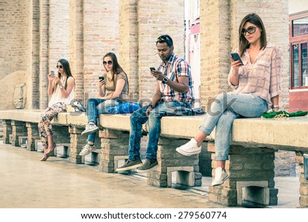 Group of young multiracial friends using smartphone with mutual disinterest towards each other - Technology addiction in actual lifestyle - Soft vintage filtered look with main focus on male person Royalty-Free Stock Photo #279560774