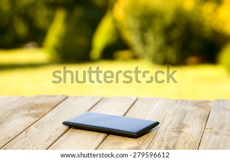 Mobile phone placed on wooden floor with nature background