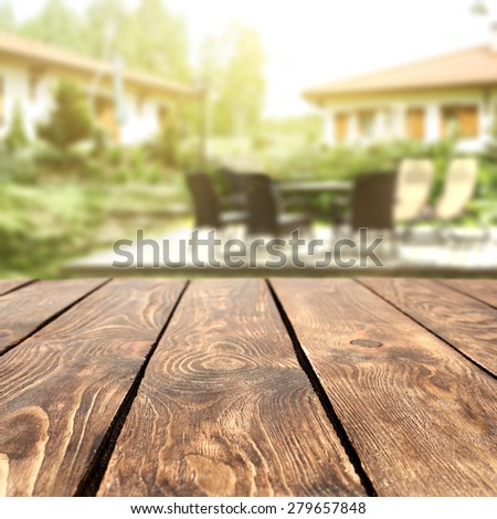 blurred background of architecture and garden with brown table 