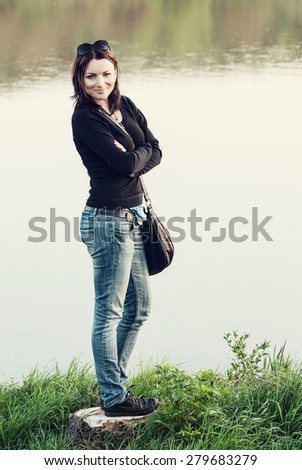 Young caucasian woman posing on the lakeshore.