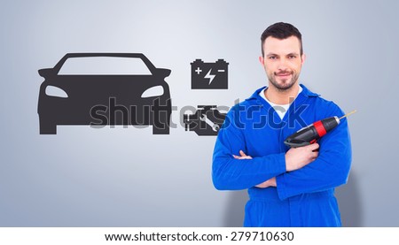 Confident handyman holding power drill against grey vignette