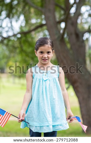 Little girl waving american flag on a sunny day
