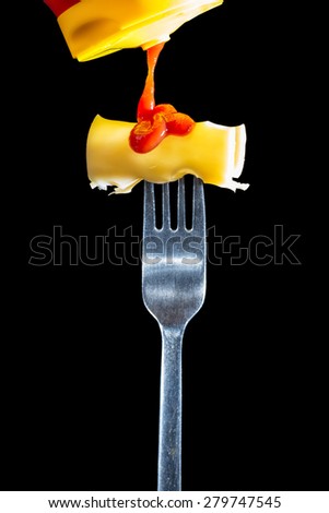 Slice of cheese on a fork with ketchup