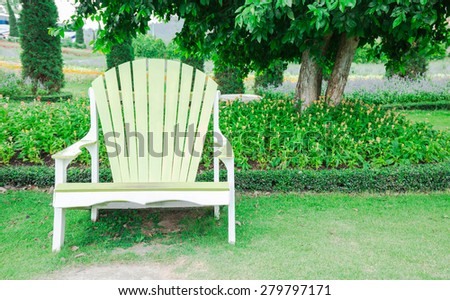 Big wooden chair in green garden