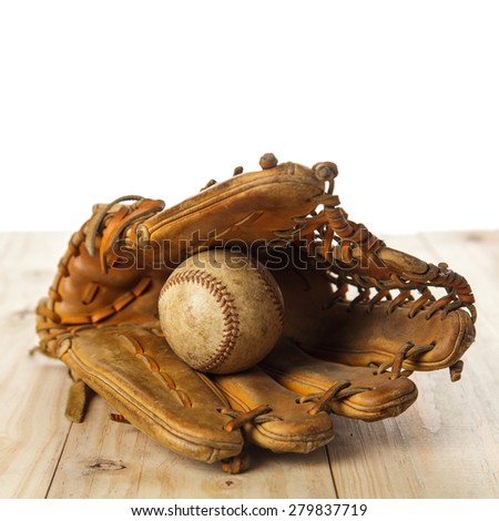 Old baseball glove with baseball on wood background