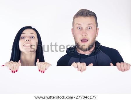 couple peering from a poster